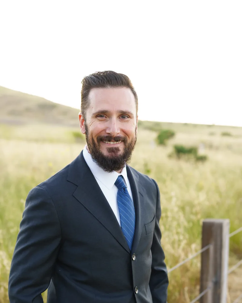 Kyle D. Smith, a California employment lawyer, smiling in a sunlit field